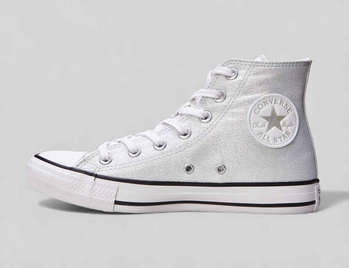 Tênis Converse feminino Chuck Taylor All Star CT2564 prateado com glitter, vista lateral direita destacando o patch com logo redondo.