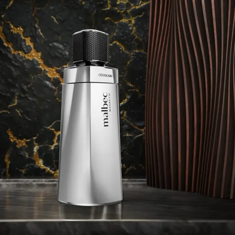 Frasco de Malbec Magnetic posicionado sobre superfície de mármore com fundo escuro e dourado.