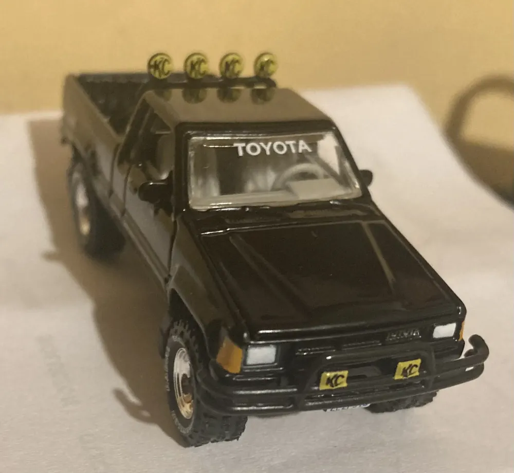 Johnny Lightning 1985 Toyota SR5 Pickup Bianco, Livrea Racing 4x4, Scala 1/64