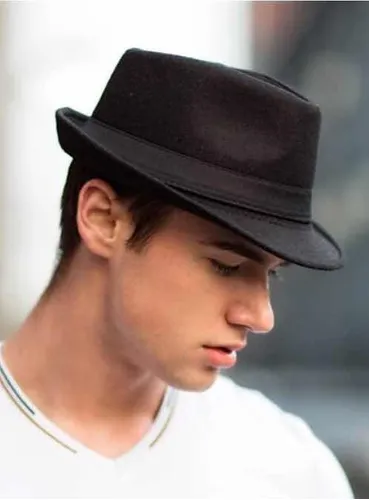 Come indossare cappelli da uomo per migliorare il tuo look 1 Un giovane uomo che indossa un nero Fedora