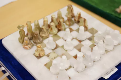 Lote 7 - JOGO DE XADREZ EM ONIX E MÁRMORE - Conjunto de tabuleiro e peças  de jogo de xadrez em ónix e mármore. Algumas peças com falhas e colegens.  Dim: 40x40