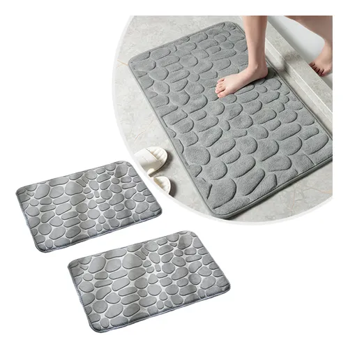 Kit com dois tapetes de banheiro cinza com textura de pedras e pés sobre um deles
