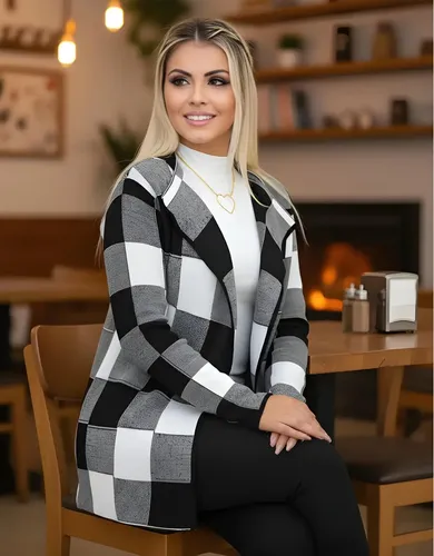 Modelo loira usando cardigan xadrez sentado em uma mesa de madeira