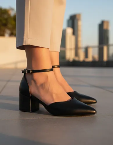 Pessoas usando sapatos de salto bloco preto em um ambiente externo com prédios ao fundo