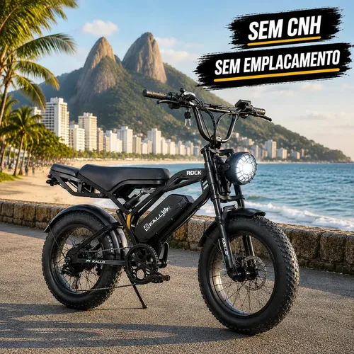 Bicicleta elétrica Kallo Rock preta em uma ciclovia costeira, com o Morro Dois Irmãos e a cidade do Rio de Janeiro ao fundo, destacando 'SEM CNH' e 'SEM EMPLACAMENTO'.
