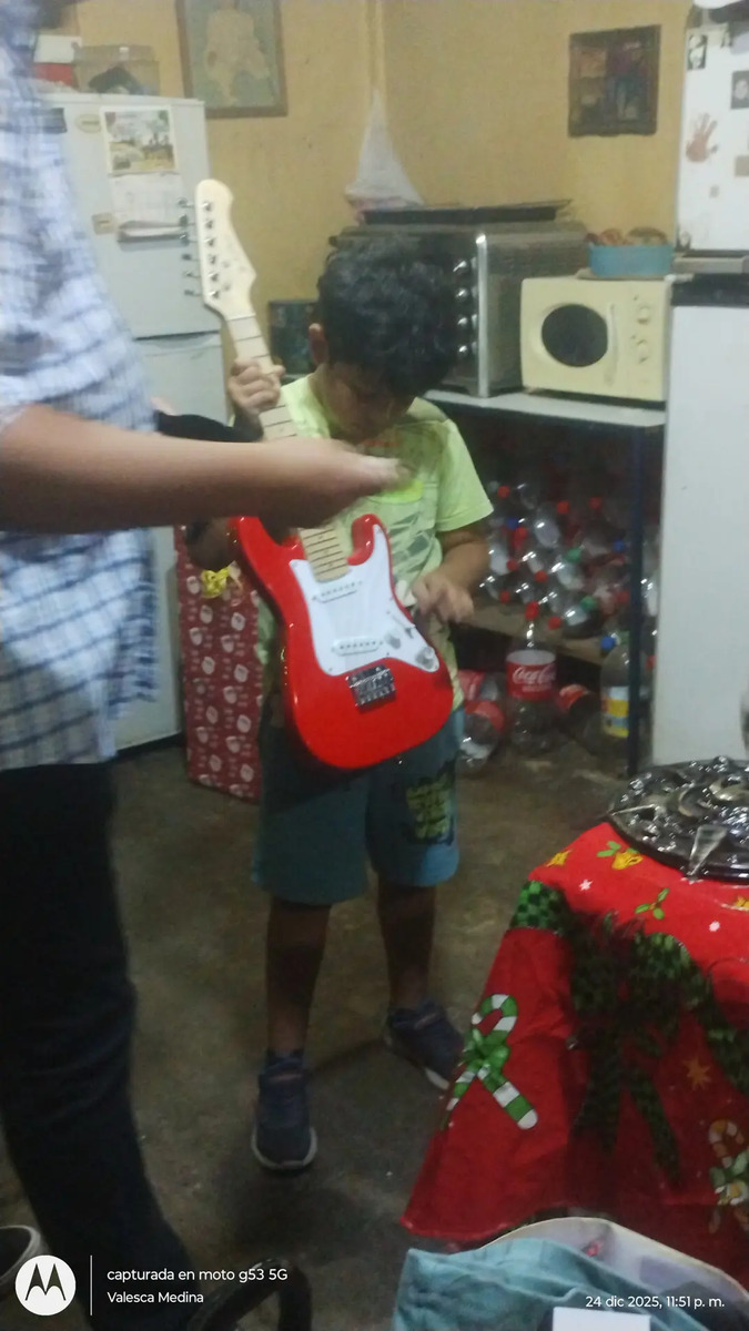 Niña con su guitarra eléctrica infantil Ibrah roja, foto real de cliente