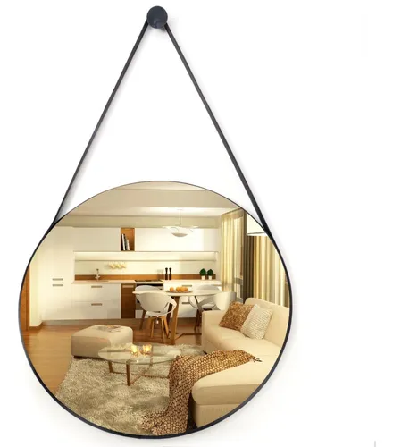 Espelho Adnet redondo com moldura e alça pretas, refletindo um ambiente de sala de estar e cozinha integradas, com decoração moderna em tons claros.