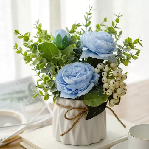 Flores artificiales con pequeño jarrón de cerámica, hortensias