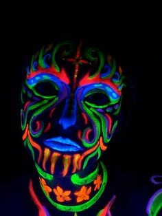 La cara del hombre pintada en neón uv lava. Retrato conceptual de un hombre pintado con colores fluorescentes uv y parece | CanStock