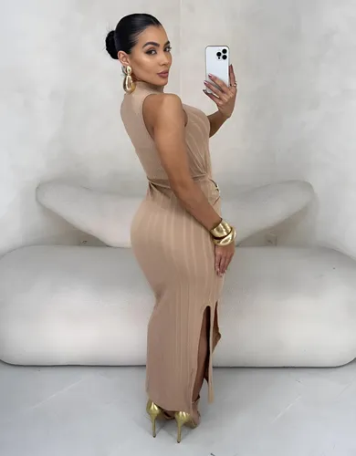 Mulher de costas e perfil vestindo vestido midi bege com cinto de fivela e fenda lateral.