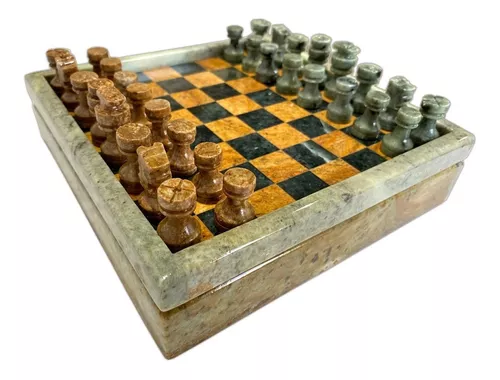 Parte do tabuleiro de xadrez com peças de xadrez em pedra com pedras no  fundo