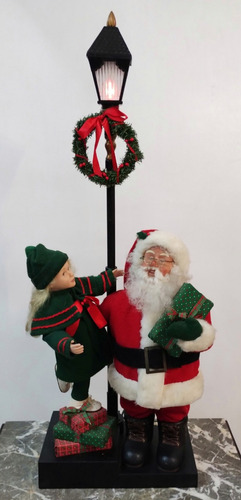 Santa Y Niña Animados En Poste De Luz. Decoración De Navidad