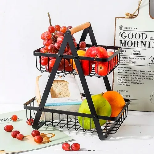 Frutero en uso con frutas variadas Frutero de metal y madera en uso en la cocina con frutas