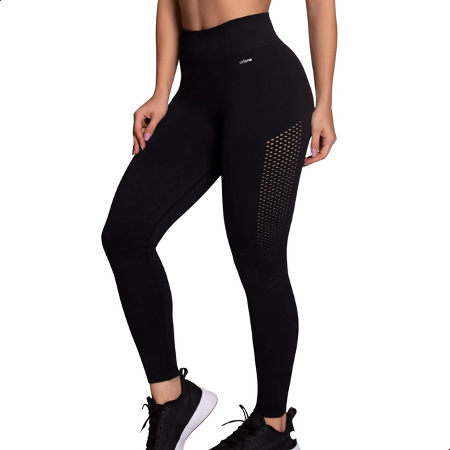 Modelo vestindo legging preta Selene de alta compressão com detalhes texturizados nas laterais e cós alto