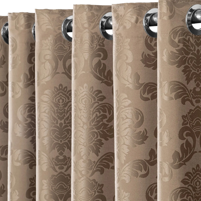 Detalhe em close da cortina de tecido Jacquard bege com estampa floral em relevo e ilhoses metálicos instalados em um varão.