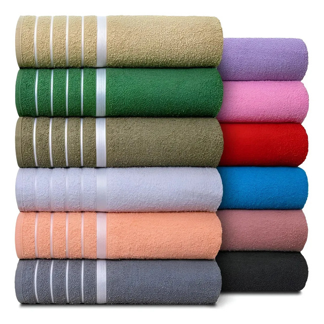 Pilha organizada de toalhas de banho gigantes Softmax em diversas cores, incluindo tons de verde, azul, cinza, rosa e bege.