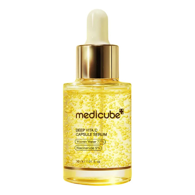 Frasco de vidro transparente do sérum facial Medicube Deep Vita C contendo líquido amarelado com pequenas cápsulas suspensas, com tampa dourada e conta-gotas.