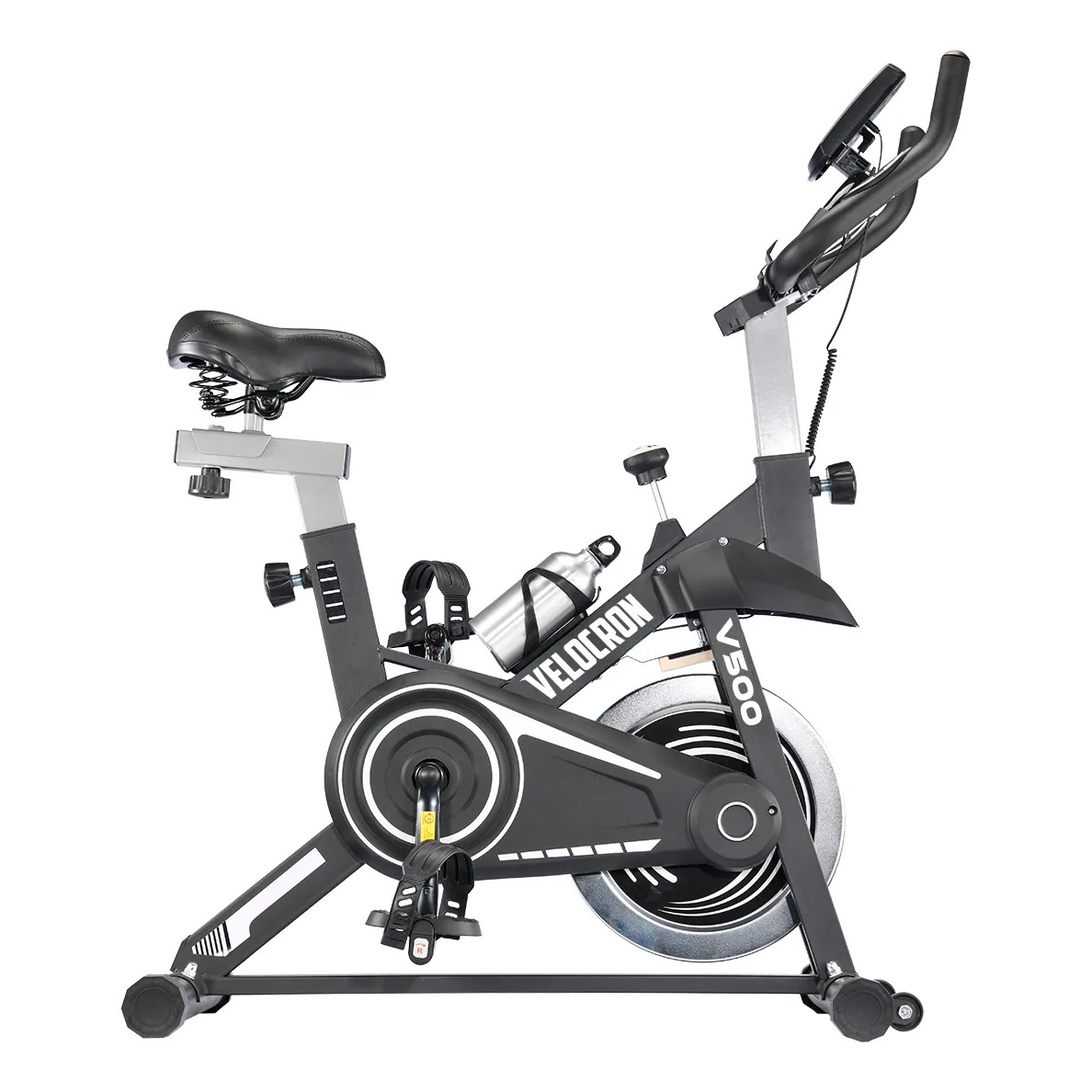 Bicicleta ergométrica de spinning Velocron V500 na cor preta, vista lateral, com suporte para garrafa e painel digital no guidão.