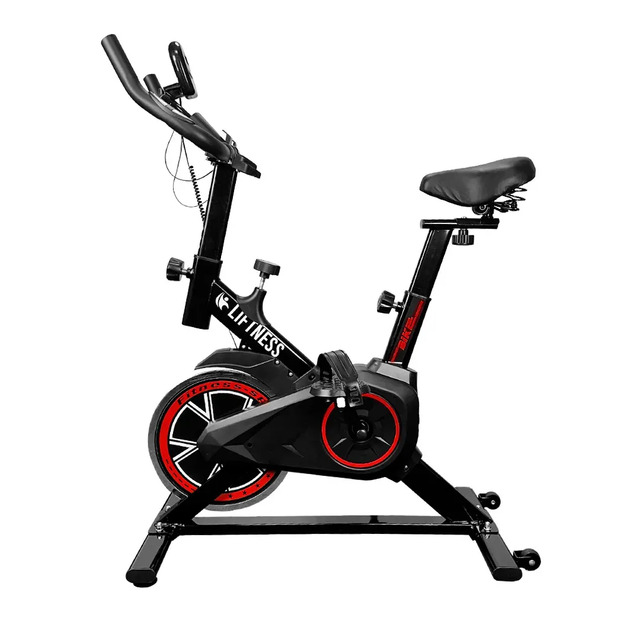 Bicicleta ergométrica spinning da marca Liftness na cor preta com detalhes em vermelho, exibindo guidão com medidor cardíaco, assento ajustável e estrutura de aço.