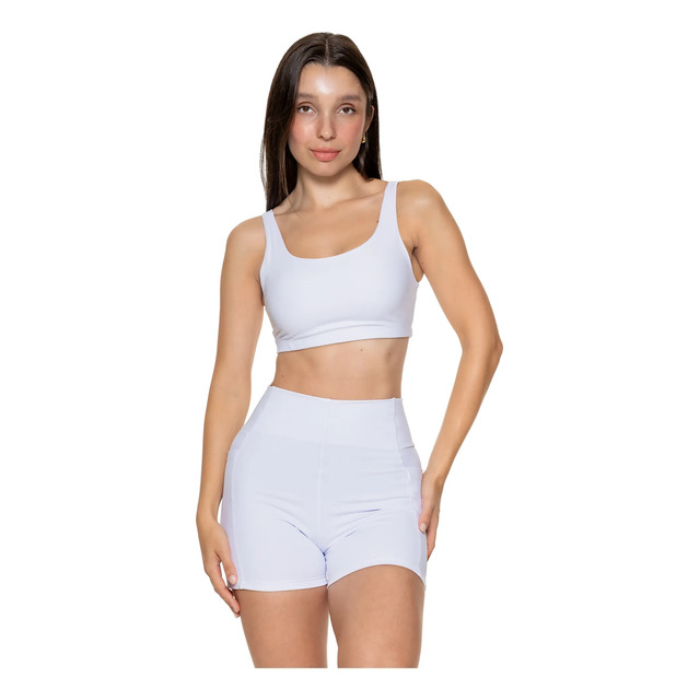 Modelo vestindo conjunto fitness branco composto por top de sustentação dupla e short com bolsos laterais