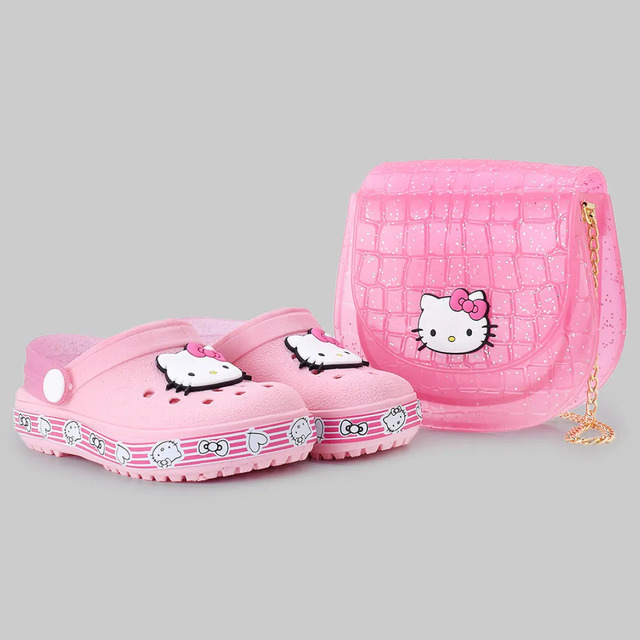 Kit infantil contendo um par de babuches rosa da Hello Kitty e uma bolsa transversal rosa com textura croco, brilhos e estampa da personagem