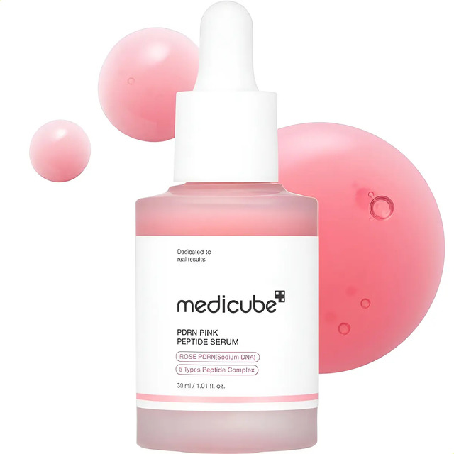 Frasco de vidro fosco do sérum Medicube PDRN Pink Peptide com conta-gotas, acompanhado de gotas do produto em tom rosado flutuando ao redor.