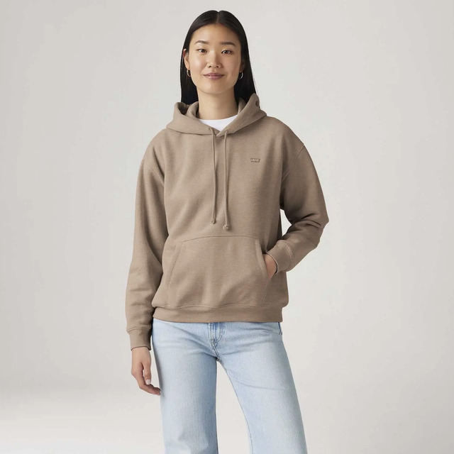Modelo feminina vestindo moletom marrom da Levi's com capuz, cordões ajustáveis e bolso frontal tipo canguru, sobre fundo cinza claro.