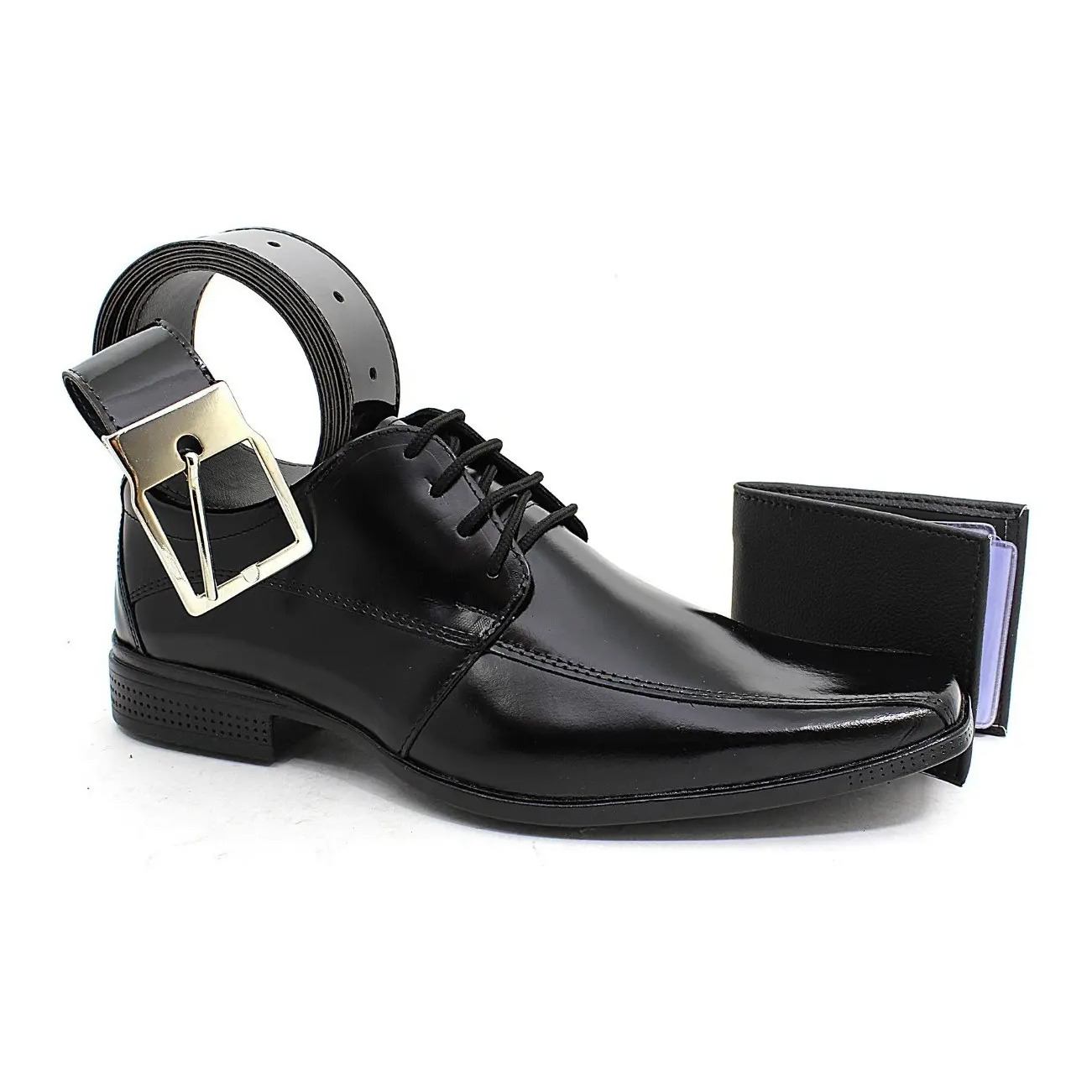 Kit masculino contendo um sapato social preto com cadarço, um cinto de couro preto com fivela metálica e uma carteira preta, dispostos sobre fundo branco.