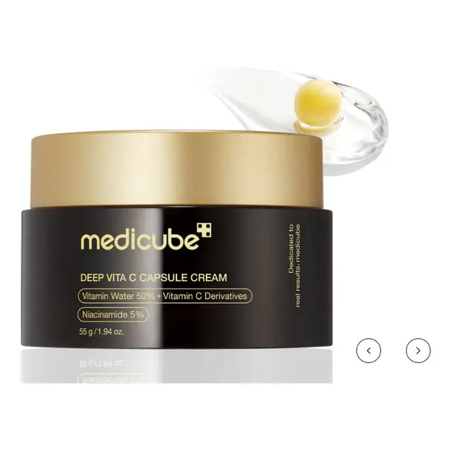 Pote de creme facial Medicube Deep Vita C Capsule Cream com tampa dourada e uma gota de produto acima com uma cápsula visível