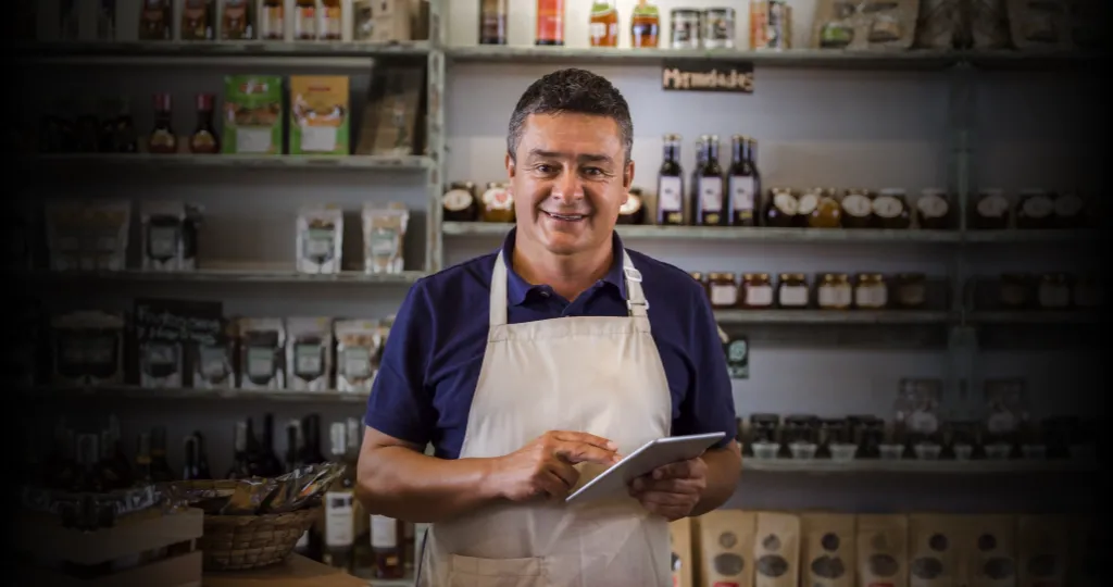 Un usuario de Mercado Crédito de pie en su local comercial