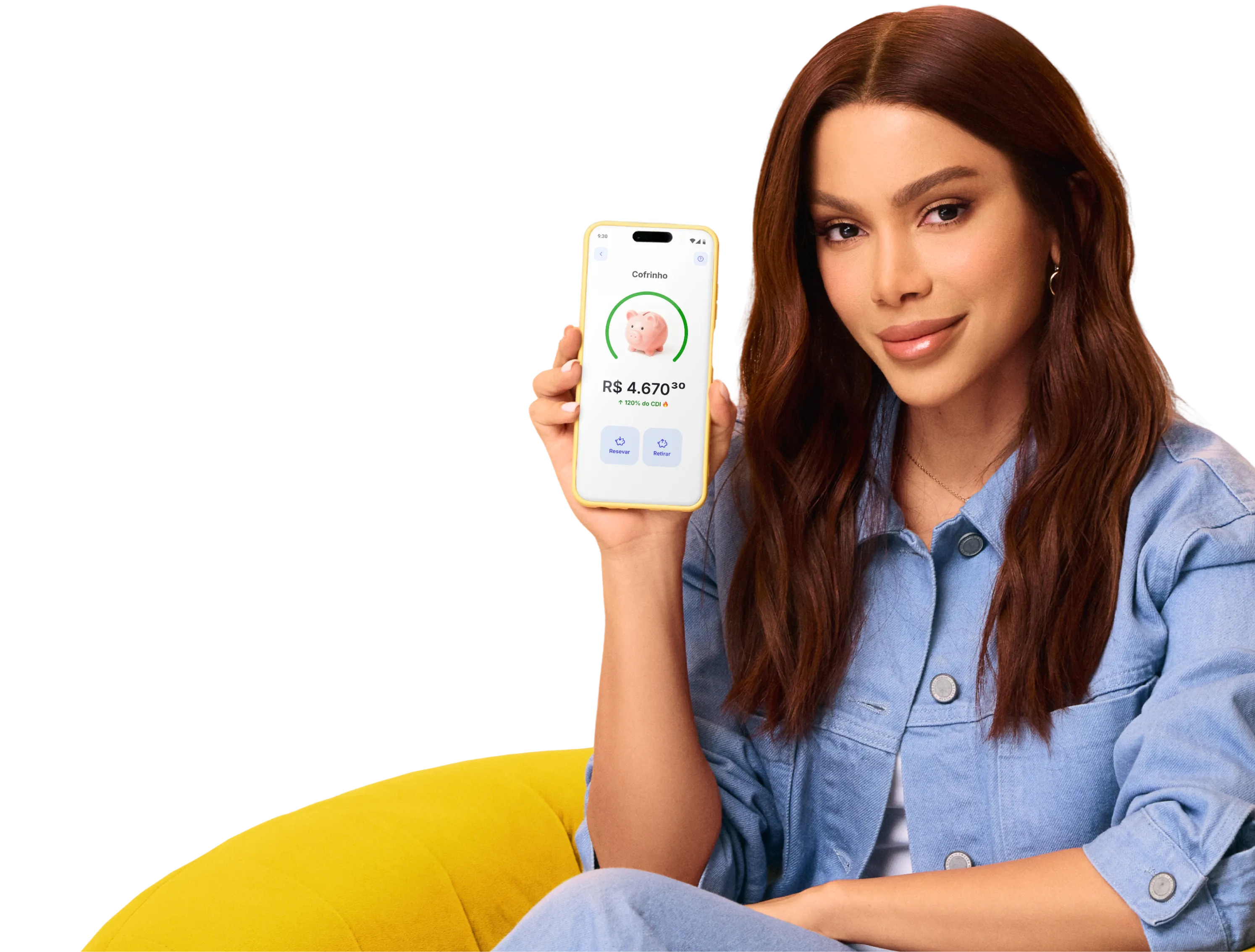 Imagem da cantora Anitta segurando um celular em que a tela mostra o aplicativo do Mercado Pago onde se ve um cofrinho em formato de porco.