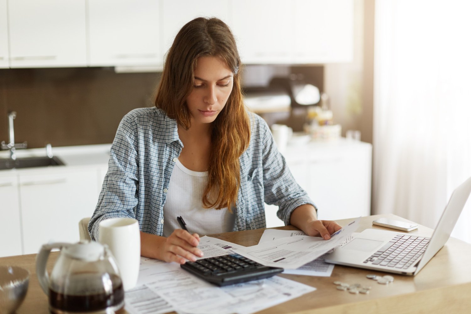 Pessoa calculando amortização de parcelas de empréstimo pessoal em casa.