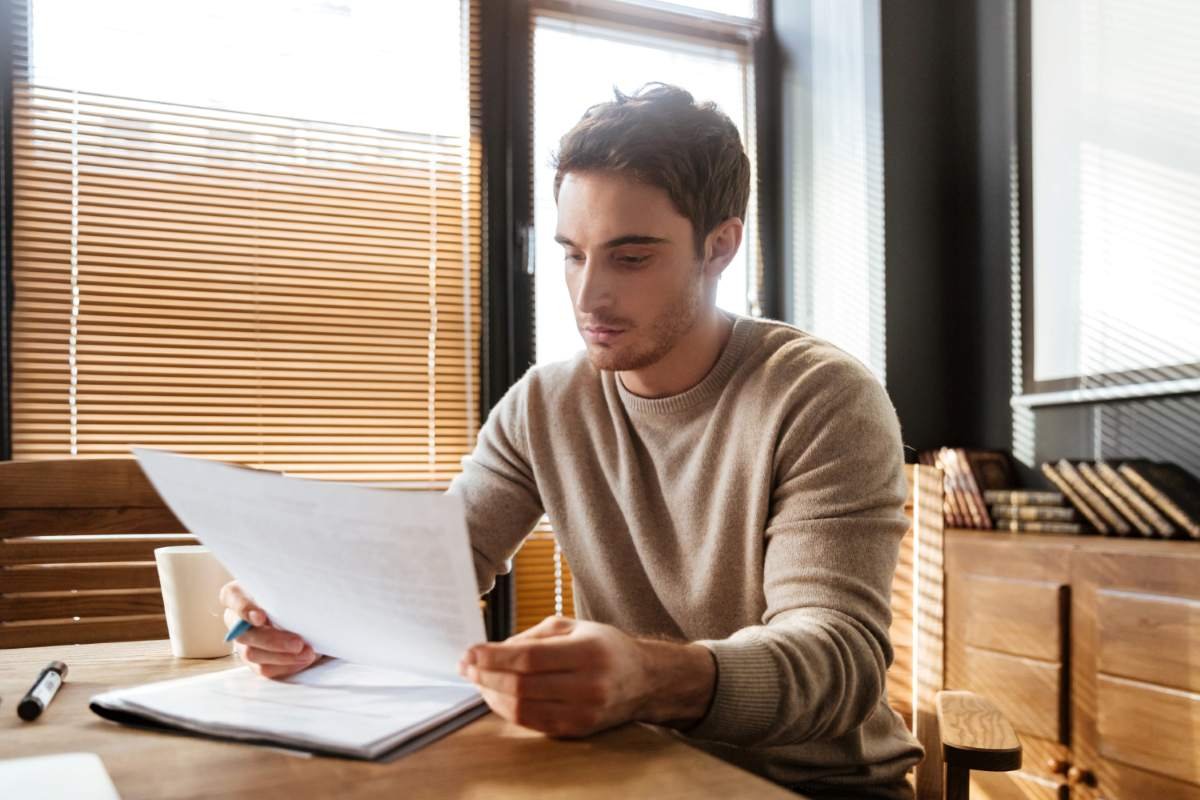 Hombre leyendo un contrato financiero antes de firmar.