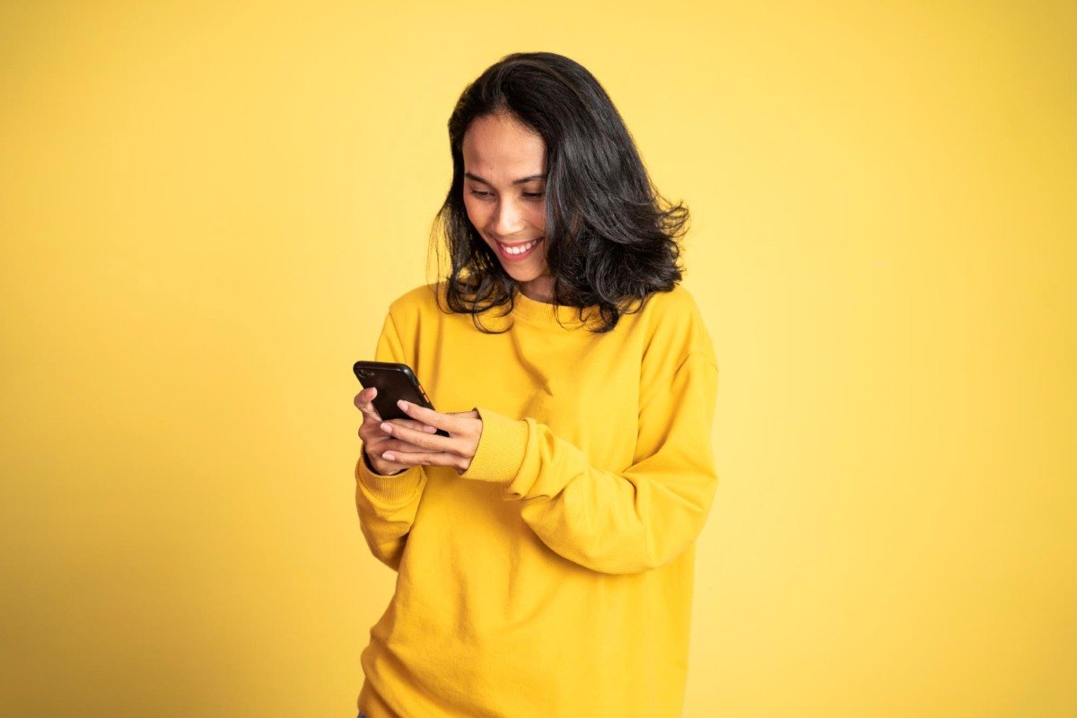 Cliente conferindo no celular cashback recebido após compra.