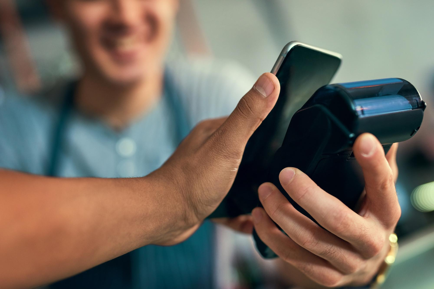 Persona usando métodos de pago digitales con celular en comercio mexicano.
