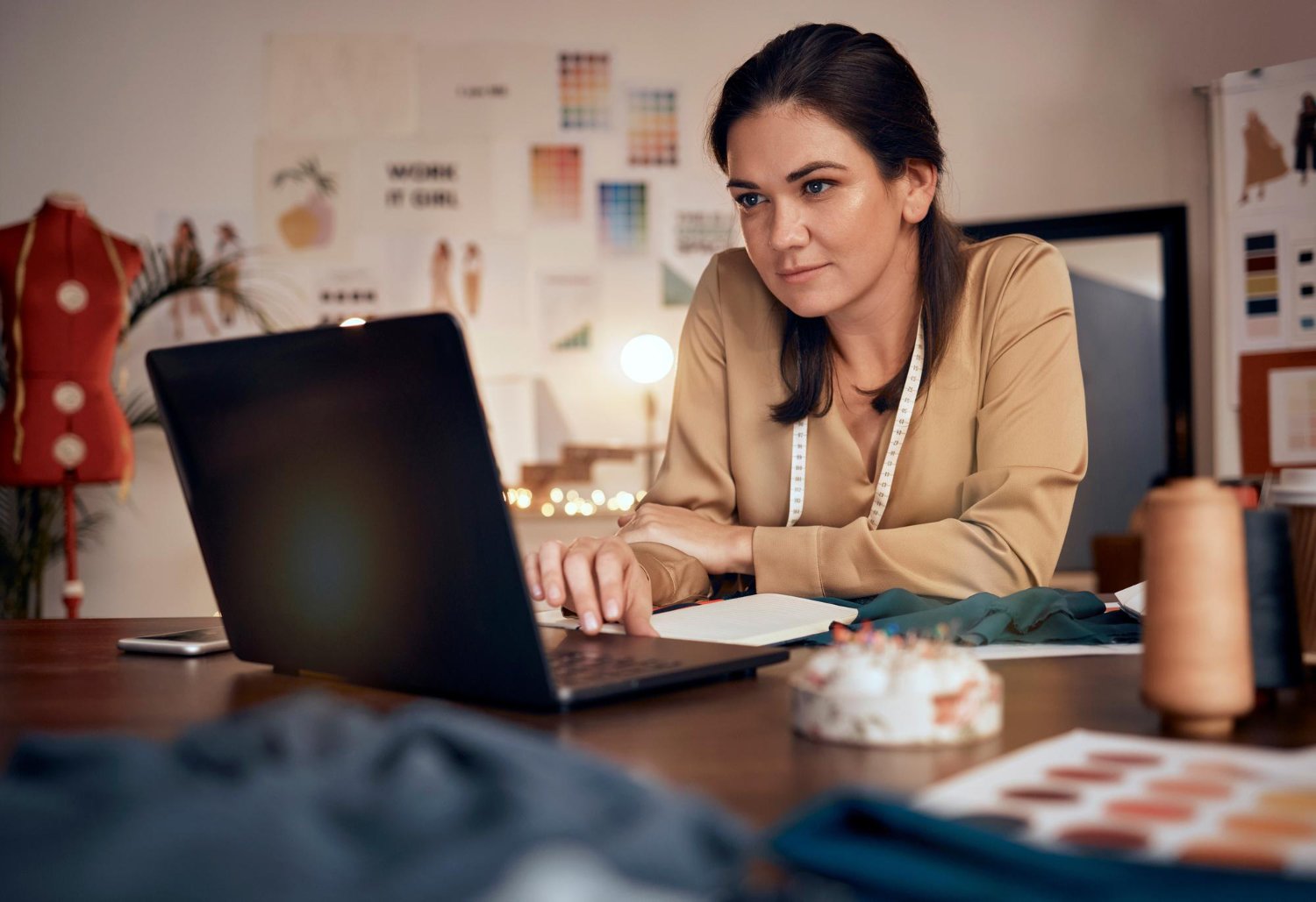 Empreendedora lendo relatório de vendas do Mercado Pago no computador.