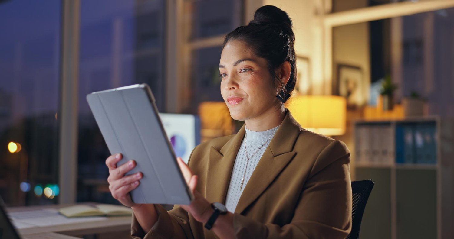 Empreendedora usando tablet para gerenciar finanças empresariais.