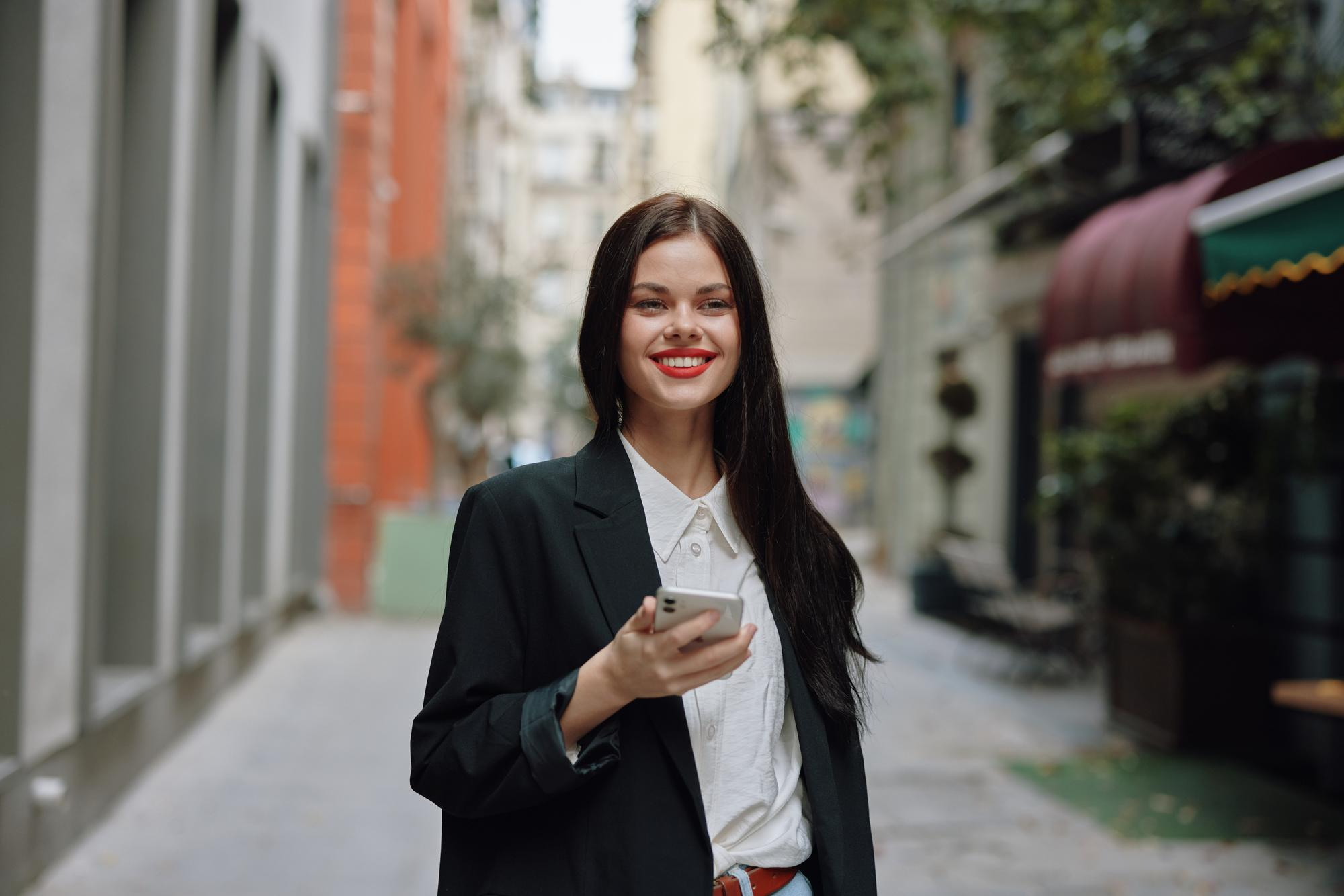 Empresária usando o celular para programar investimentos automáticos na conta da empresa