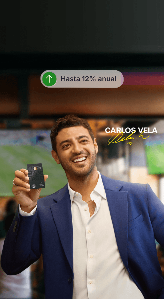 Carlos Vela sosteniendo una tarjeta Mercado Pago en un bar. Tu dinero crece hasta 12% anual.