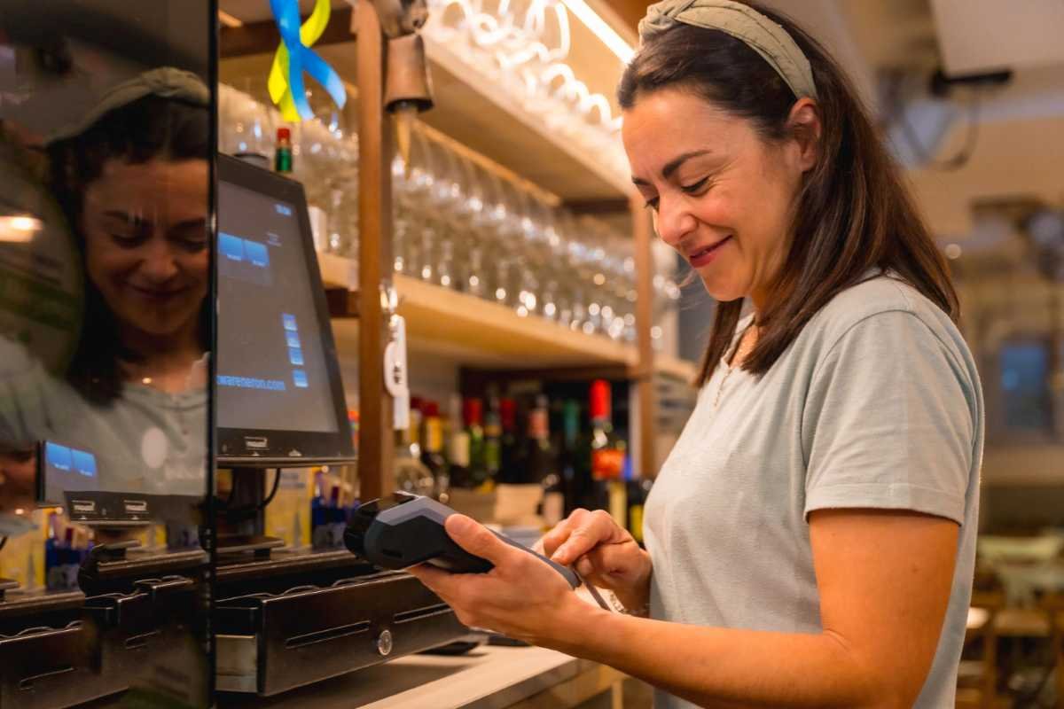 Pessoa configurando rede na sua maquininha de cartão em ambiente comercial