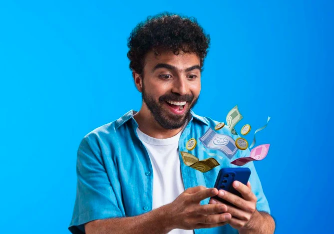 Homem vestindo camiseta branca e uma camisa azul mexendo no smartphone para conferir as vantagens do rendimento Mercado Pago.