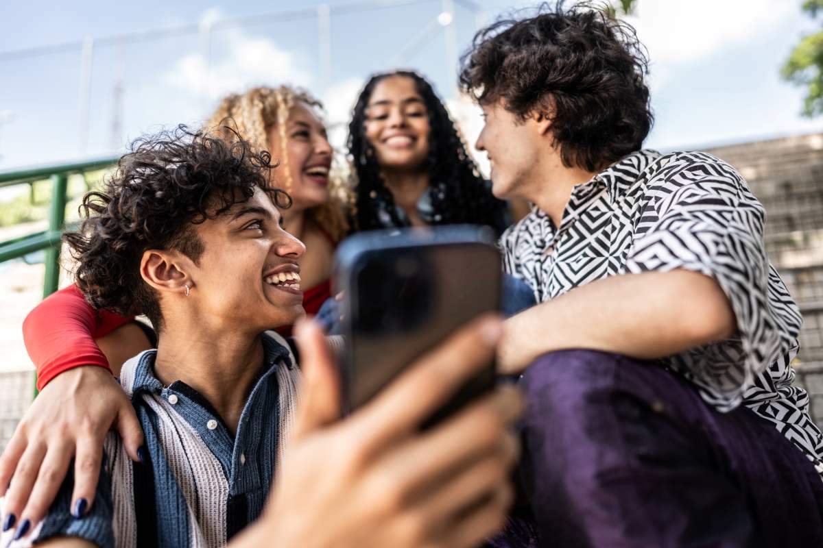 amigos-sentados-ven-celular
