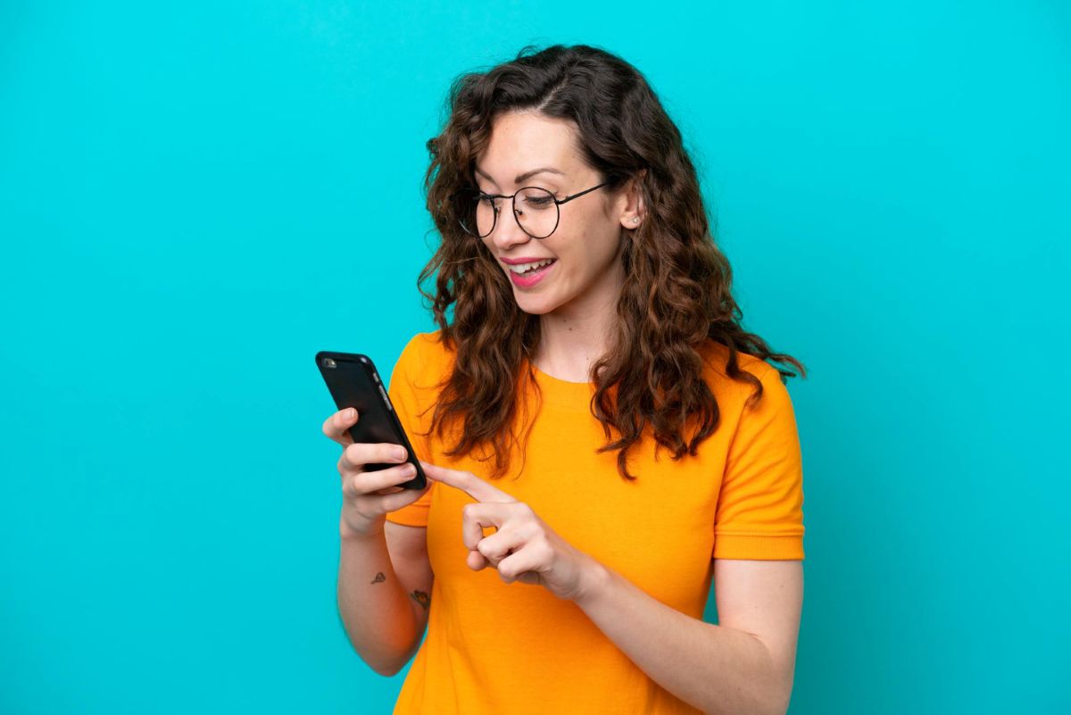 Mulher com celular entrando em contato com o atendimento Mercado Pago