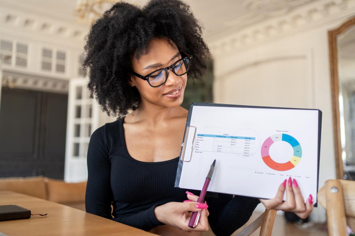 Mulher com prancheta mostrando análise de indicadores financeiros