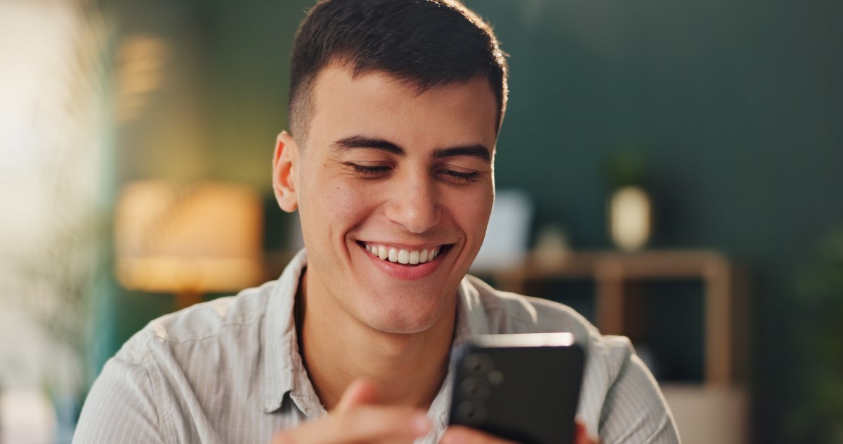 Persona mira sonriente el celular