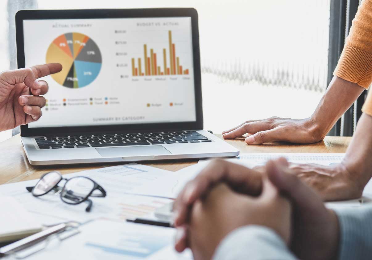 Notebook em cima da mesa com várias pessoas em volta