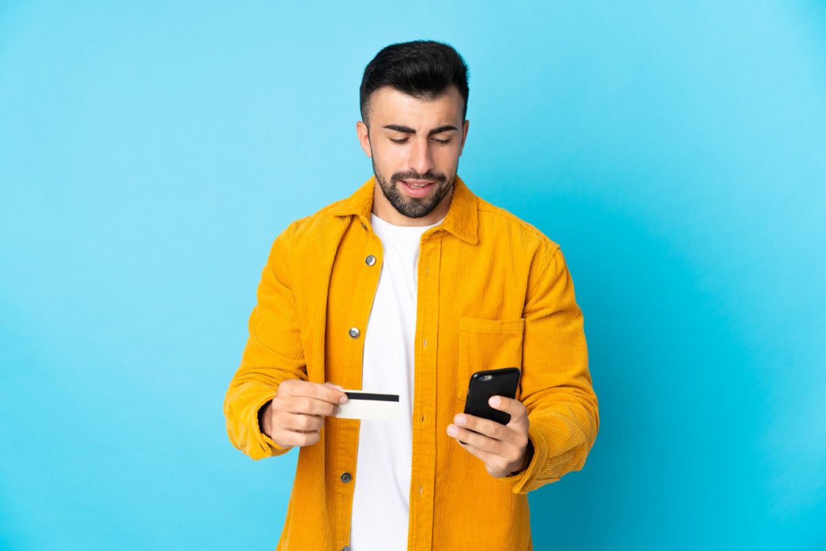 Homem usando celular para fazer compra online em BRL