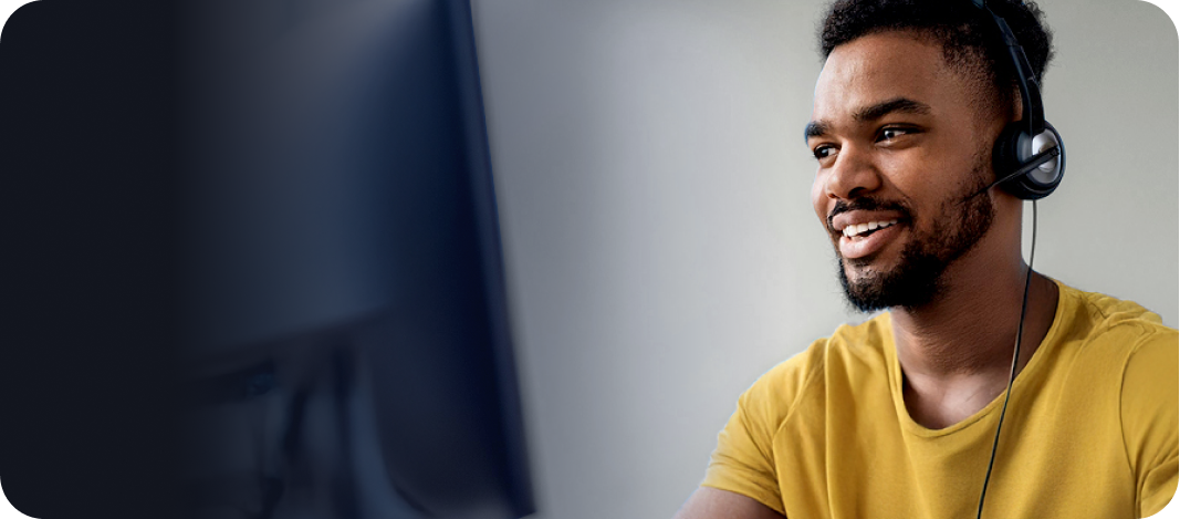 Homem negro sorrindo, usando um fone de ouvido