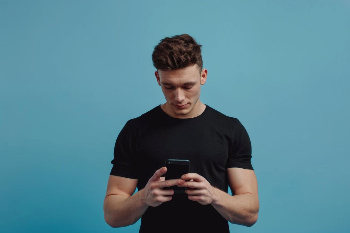 Homem usando celular para contestar compra de videogame