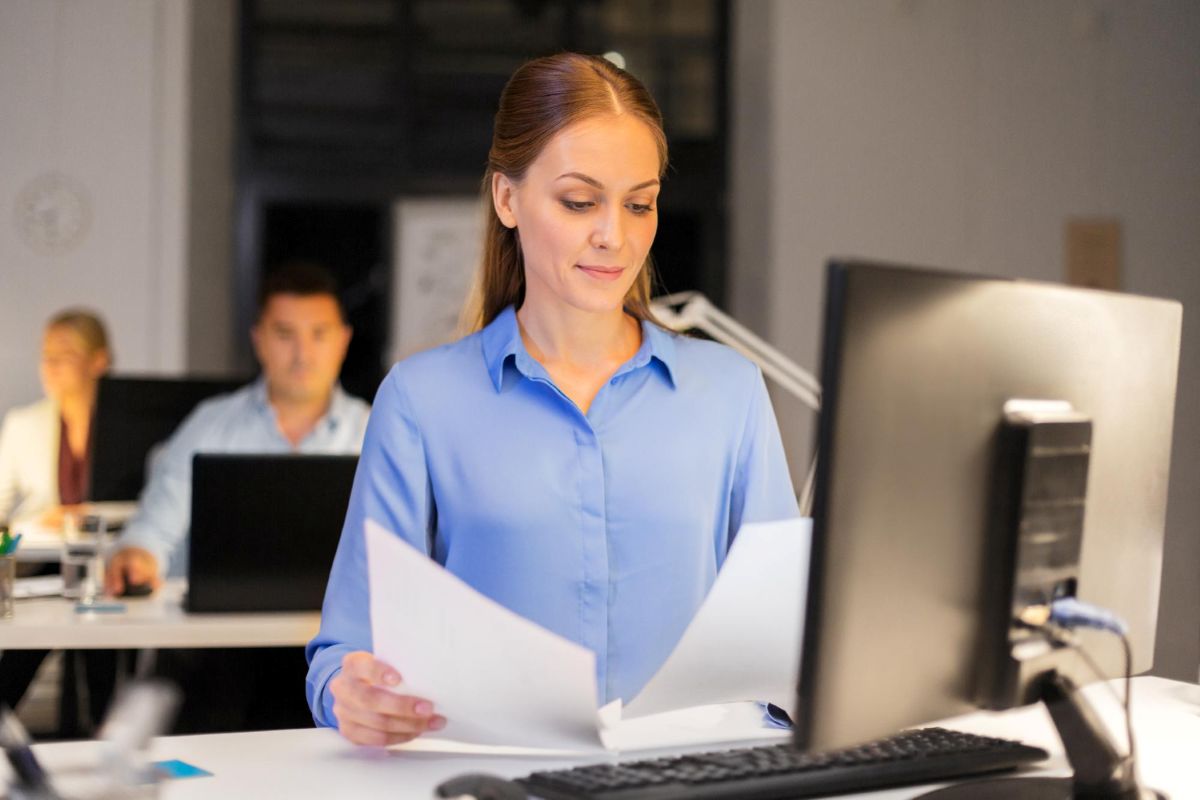 Empresária trabalha em escritório analisando documentos.